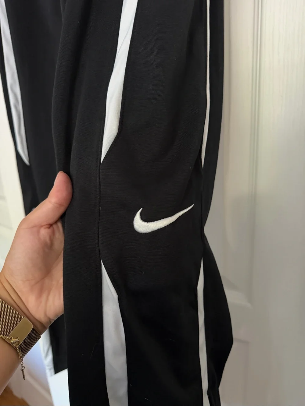 Nike black men’s track pants with white side stripes, size M